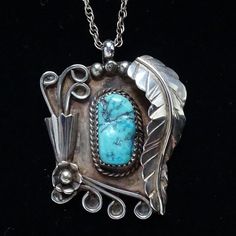 This is a Native American Navajo Shadowbox Turquoise Nugget Pendant Necklace Elaborate 925 Applique 19". This pendant necklace features a gorgeous turquoise nugget stone that is sawtooth bezel set in shadowbox with elaborate applique work that includes a long feather, raindrops, a cone with curled wire for flowers, more curled wire and a flower with raindrop center. Unsigned  Condition: Excellent vintage condition. Style: Pendant Necklace Metal: 925 Sterling Silver (tested) Surface: Polished Bail measures 3mm diameter Chain: Marked Sterling; measures 19" Measurement: 1 5/8" long; 1 3/8" wide Weight: 14.6 grams  Hallmark: A. Penketewa (Alan Penketewa) Tribal Affiliation: Navajo Native American #2641963 Western Style Collectible Turquoise Sterling Silver Necklace, Western Style Turquoise Necklace With Large Pendant, Western Turquoise Necklace With Large Pendant For Gifts, Western-style Turquoise Necklace With Large Pendant As Gift, Western Style Turquoise Necklace With Large Pendant As Gift, Southwestern Style Engraved Turquoise Necklaces, Western Style Silver Turquoise Necklace As Gift, Southwestern Turquoise Sterling Silver Collectible Necklace, Southwestern Engraved Turquoise Necklace