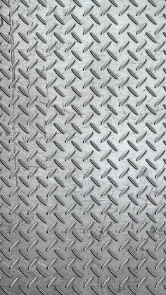 a close up view of a metal diamond plate textured with rivets and lines