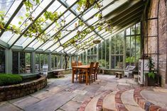 the inside of a glass house with tables and chairs