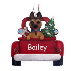 a christmas ornament with a dog sitting in the back of a red truck