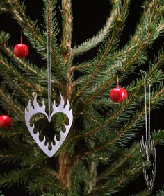 a heart shaped ornament hanging from a christmas tree with baubles on it