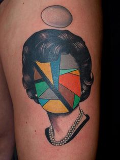 a woman's face with an abstract design on her arm and shoulder, done in black and grey