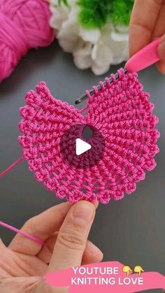 someone is holding a crocheted object with pink yarn on it and the words youtube knitting love written in white