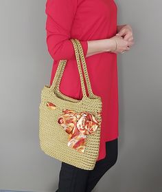 a woman in red shirt carrying a straw bag