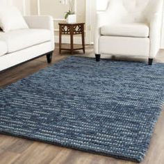 a living room with two white chairs and a blue rug