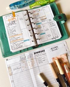 an open planner with pens and markers on it