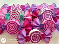 several pink and purple lollipops with glitter bows