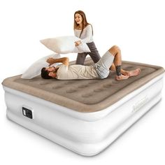 a man and woman laying on top of an inflatable mattress with a pillow