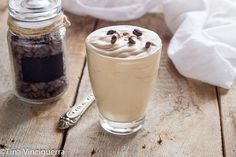 there is a drink with whipped cream and chocolate chips on the table next to it