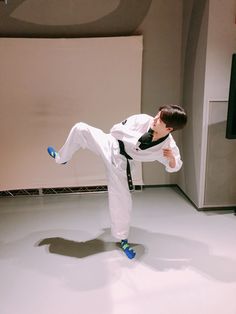 a young man is practicing karate moves on the floor