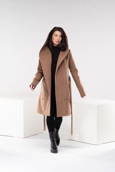 "Wrap yourself in timeless elegance with our hooded wool coat. This luxurious coat is designed for both warmth and fashion, featuring a classic hood and two spacious pockets for your convenience. The long belt allows you to achieve that chic look while ensuring a perfect fit. Embrace the essence of sophistication and stay cozy in style with this exquisite coat, a must-have addition to your winter wardrobe. ◼ FIT This hooded wool coat is of regular fit with a loose design. To have the same look as on our model, please check our body measurements size chart below and choose the correct size for you. ◾The model in the picture is wearing size XS in Camel color. ◼ FABRIC ◾wool, acryl, elastane with viscose lining ◼ INFO: ◾ Worldwide express shipping - please provide a phone number for shipping Brown Outerwear With Detachable Hood For Work, Hooded Brown Outerwear For Work, Brown Hooded Wool Coat For Winter, Brown Hooded Outerwear For Work, Hooded Wool Coat For Fall Workwear, Hooded Beige Wool Outerwear, Brown Hooded Wool Coat For Fall, Plus Size Peacoat, Trench Coat With Hood