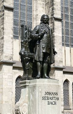 a statue of john sebastian bach in front of a church