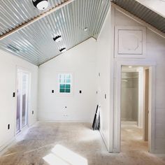 an empty room with white walls and metal roofing on the ceiling is seen in this image