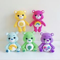 four crocheted teddy bears sitting next to each other on a white table top