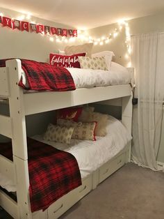 there are two bunk beds with red and white blankets on top of them, next to each other