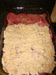 meat and cheese in a glass dish on a counter top, ready to be cooked