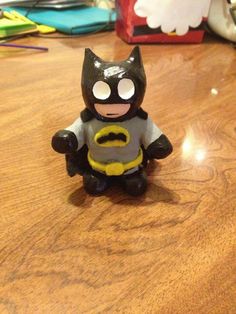 a toy batman sitting on top of a wooden table