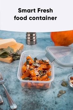 a plastic container filled with food on top of a blue counter next to silverware