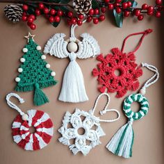 crocheted christmas ornaments hanging on a brown background with red berries and pine cones