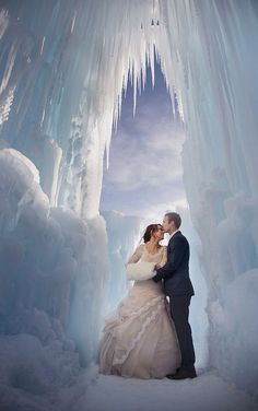 a bride and groom standing in an ice cave