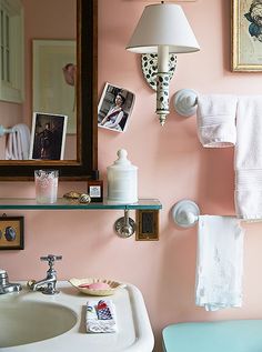 a bathroom with pink walls and pictures on the wall