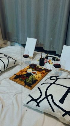 a table with wine glasses, cheese and fruit on it