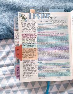 an open bible on a bed next to a blue towel with writing and magnets