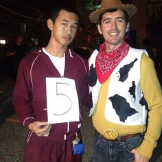 two men dressed up in costumes standing next to each other with numbers on their shirts