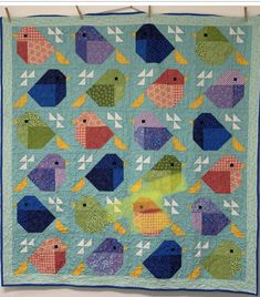 a quilt hanging on a clothes line with birds in the middle and one bird at the bottom