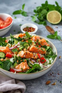 a salad with salmon and cucumbers in a bowl