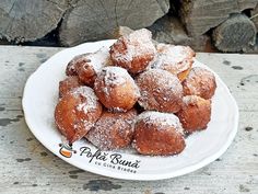 powdered sugar covered donuts on a white plate