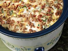 a casserole dish with meat and cheese in a blue pot on the stove