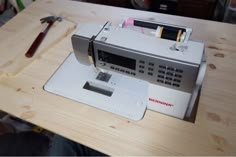 a sewing machine sitting on top of a wooden table next to a pair of scissors