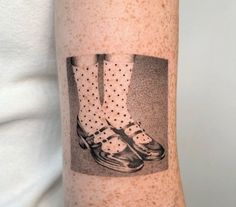 a person with a tattoo on their arm that has shoes and polka dots on it