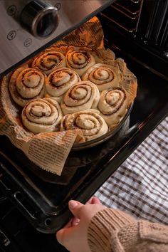 a pan filled with cinnamon rolls sitting on top of an oven