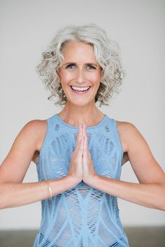 an older woman is doing yoga with her hands together