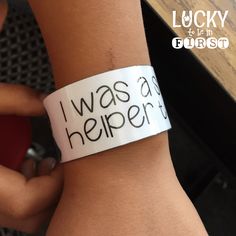 a person wearing a wristband that says i was a helper