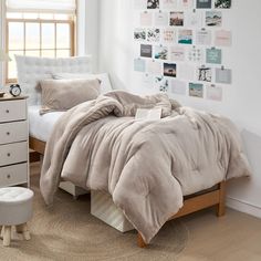 a bedroom with a bed, dresser and pictures on the wall above it is shown