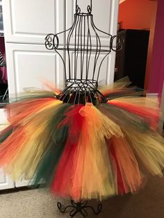 a multicolored tutule is sitting on a stand in front of a door