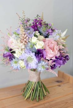 a bouquet of flowers sitting on top of a wooden table