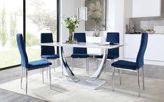 a dining room table with blue chairs around it