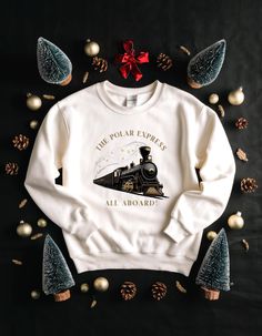 Discover the season's top trending Christmas sweatshirts, from classic designs to funny and merry options. Whether you prefer a Christmas tree, a cozy white style, or a festive message, these popular sweatshirts are perfect for spreading holiday cheer. Shop now to find your perfect fit for the holidays! Polar Express Sweatshirt, Popular Sweatshirts, Train Christmas, Trending Christmas, Train Gifts, Christmas Train, Polar Express, Christmas Trends, Sweatshirt White