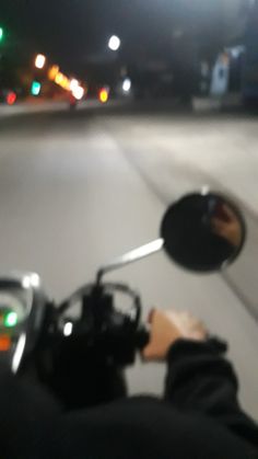 a person riding a motorcycle down a street at night