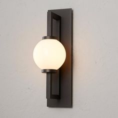 a light that is on the wall next to a white wall mounted object with a black frame