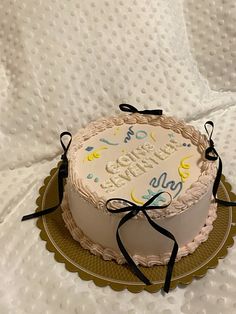 a white cake with blue and yellow lettering on it