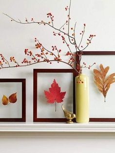 three framed pictures on a mantle with autumn leaves in vases next to each other