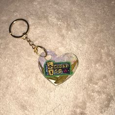 a heart shaped keychain sitting on top of a white carpet with the words crazy dog written on it