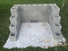 a cinder block structure sitting on top of a lush green field