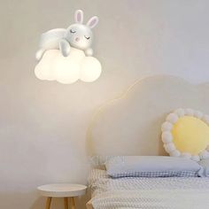 a white bed sitting next to a lamp on top of a wooden table