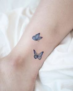 two blue butterflies tattoo on the wrist